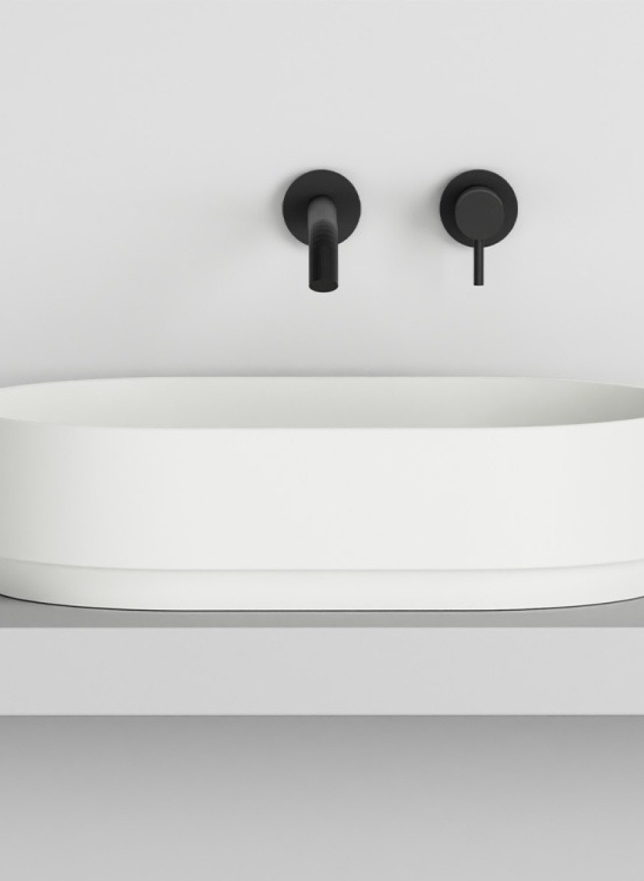 Lavabo ovalado blanco mate para baño con grifería mural en negro