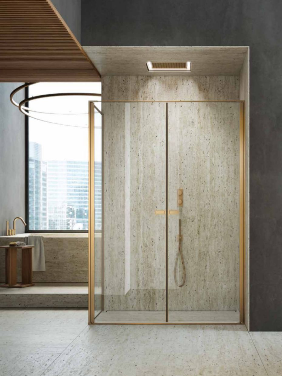 Mampara walk-in italiana con perfiles dorados y cristal transparente